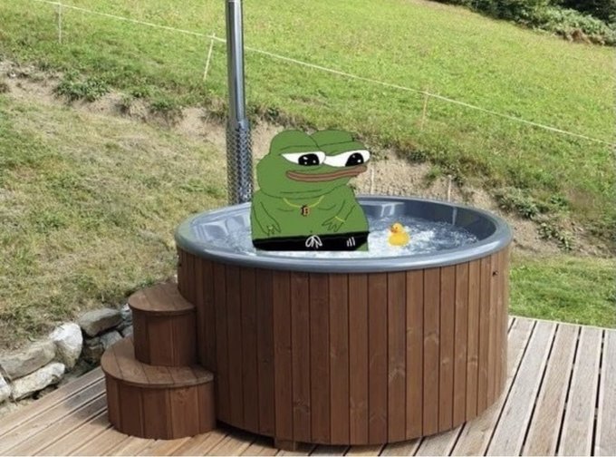 A digitally edited Pepe the Frog meme sits in a wooden hot tub with a rubber duck on an outdoor patio. The image humorously illustrates the post's "Happy Wednesday" greeting, suggesting the character is enjoying a relaxing, victorious soak to start the day.
