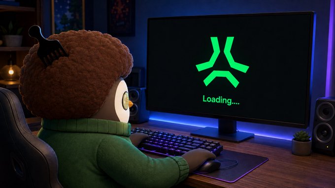 A plush penguin wearing a green sweater sits at a gaming desk in a colorful RGB-lit setup, with a "Loading...." screen and the AbstractChain logo displayed on the monitor, waiting for gameplay to begin. The image ties to the post by depicting a cozy, ready-to-play gaming scene on Saturday using the AbstractChain platform.