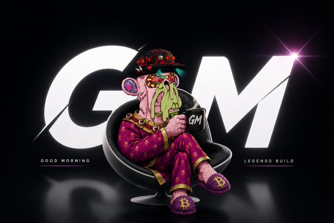 A cartoon character with a pink face, wearing sunglasses, a black hat, and purple patterned pajamas with Bitcoin symbols, sits in a black chair holding a mug with 'GM' on it, in front of large 'GM' letters and the text 'GOOD MORNING' and 'LEGENDS BUILD'.