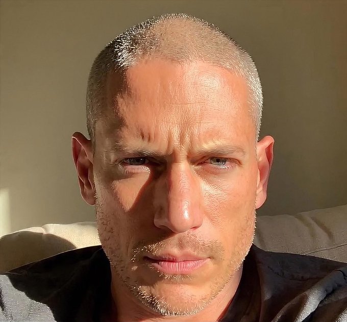 A close-up selfie of a man with very short hair and light stubble looking directly at the camera.