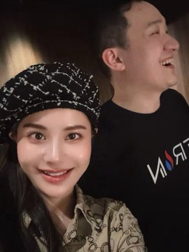 A young woman wearing a black and white patterned beret and beige printed shirt poses for a selfie with Justin Sun, who is laughing joyfully in the background while wearing a black t-shirt with the "NASA" logo visible. The image captures a warm, candid moment between the two at a Huobi Global dinner, reflecting the post's sentiment about Sun's charismatic energy.