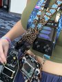 A close-up of someone working on multiple circuit boards and electronic devices, possibly a miner or technician handling cryptocurrency hardware.