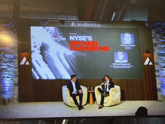 Two men sit in chairs on a stage having a discussion in front of a screen displaying 'avalanche' branding, 'FIRE&ICE NEW YORK', and 'NYSE's MICHAEL BLAUGRUND' as the featured speaker.