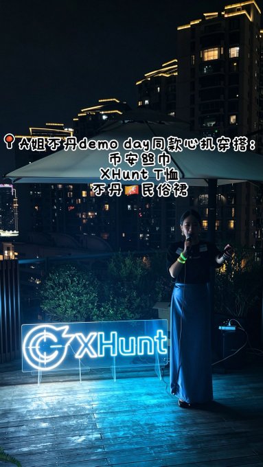 A woman stands at night under an umbrella near a glowing 'GXHunt' sign, with Chinese text promoting a limited edition lantern bag and t-shirt from a demo day.