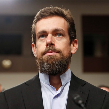 A bearded man in a dark suit and light blue shirt, identified as Jack Dorsey, looks upward with a serious expression during what appears to be a formal hearing or testimony. His contemplative demeanor complements the post's message about his prediction that Bitcoin will replace national currencies as the single global currency.