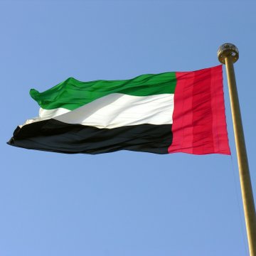 The United Arab Emirates flag waves against a clear blue sky, symbolizing the nation behind the announcement that its TDRA is migrating the UAEPASS Digital Vault to a dedicated Avalanche L1 to secure digital IDs for 12.5 million citizens, residents, and visitors.
