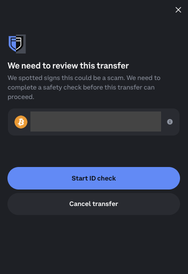 A Coinbase-style security modal warning 'We need to review this transfer' for a suspicious Bitcoin transfer, offering options to 'Start ID check' or 'Cancel transfer'.