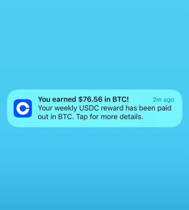 A notification from Coinbase (app icon visible) shows: "You earned $76.56 in BTC! Your weekly USDC reward has been paid out in BTC. Tap for more details." The image directly ties to the caption by celebrating USDC rewards being delivered, showing the moment the user's weekly earnings arrived in Bitcoin.