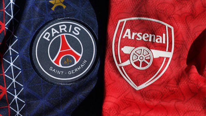 The image features a close-up of two soccer jerseys, one red and one blue with the logos of Paris Saint Germain (PSG) and Arsenal. The red jersey has a white logo that reads "Arsenal" on the back, while the blue jersey displays a black logo for PSG. Both jerseys are displayed against a gray background, making them stand out prominently in the image.