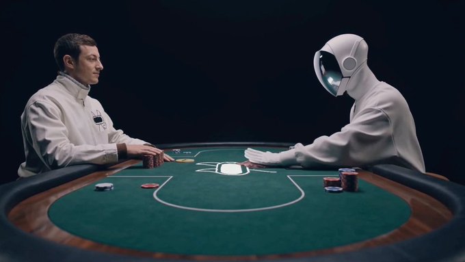 Two individuals, a man and a robot, engage in a poker game at a green table with red chips, set against a black background.