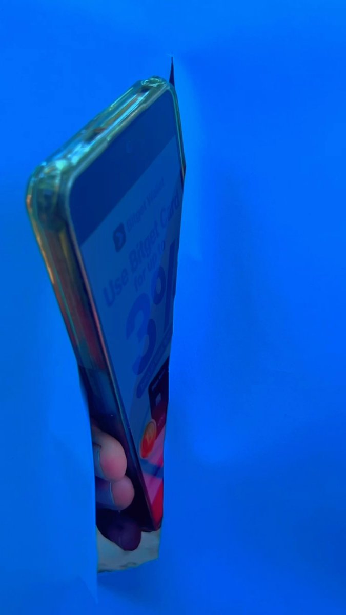 A side-angle photograph of a smartphone showing a banking app screen with the partially visible text 'Use Biomet...' against a bright blue background.