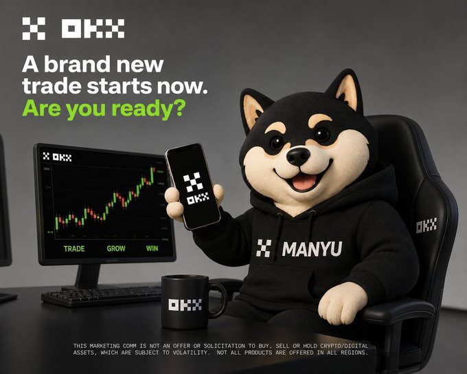 An advertisement featuring a black Shiba Inu dog mascot in a black 'MANYU' hoodie sitting in a gaming chair. The text reads 'OKX - A brand new trade starts now. Are you ready?' with a computer monitor showing a stock chart and the OKX logo on a phone and coffee mug.