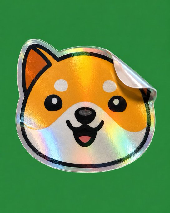 A shiny holographic sticker featuring a cartoon Shiba Inu dog face (the Doge meme) against a green background, with a peeled corner revealing the silver backing.