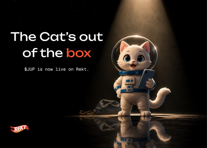 A promotional graphic featuring a cartoon cat astronaut in a space suit, with the tagline 'The Cat's out of the box' announcing that '$JUP is now live on Rekt,' with the REKT logo at the bottom.