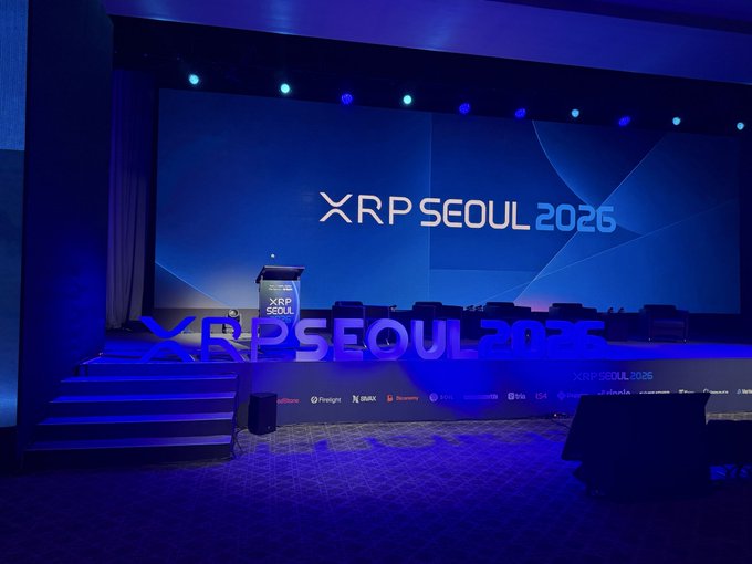 A stage set up for the 'XRP SEOUL 2025' conference, featuring blue illuminated letters and a podium in front of a large screen displaying the event logo.