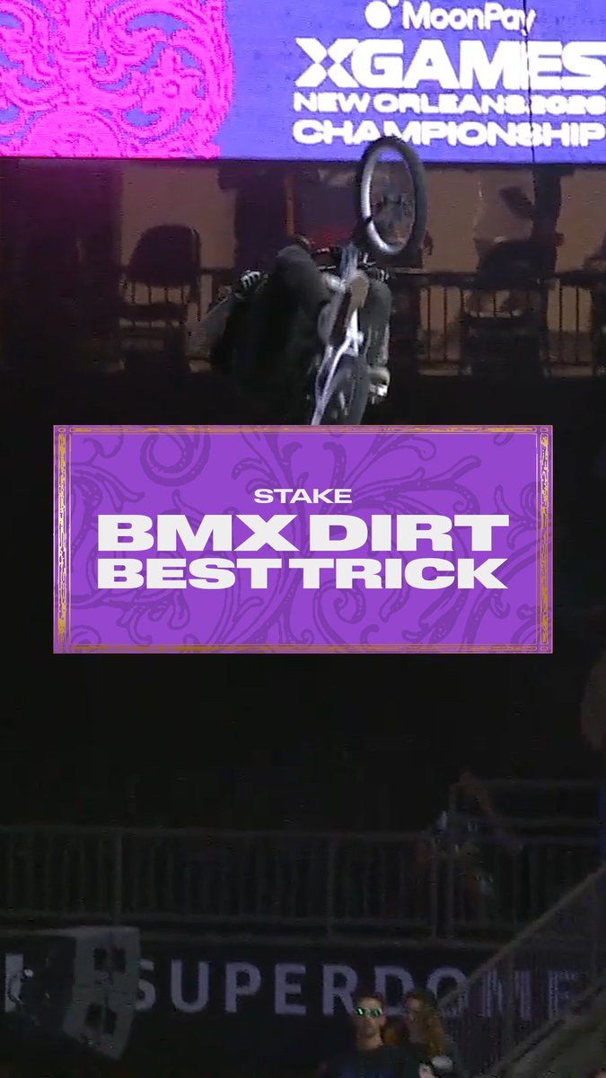 A BMX rider performs an aerial trick upside down at the MoonPay X Games New Orleans 2026 Championship, with on-screen graphics announcing "STAKE BMX DIRT BEST TRICK." The image aligns with the post celebrating Brandon Loupos's gold medal win in this event held at the Superdome.