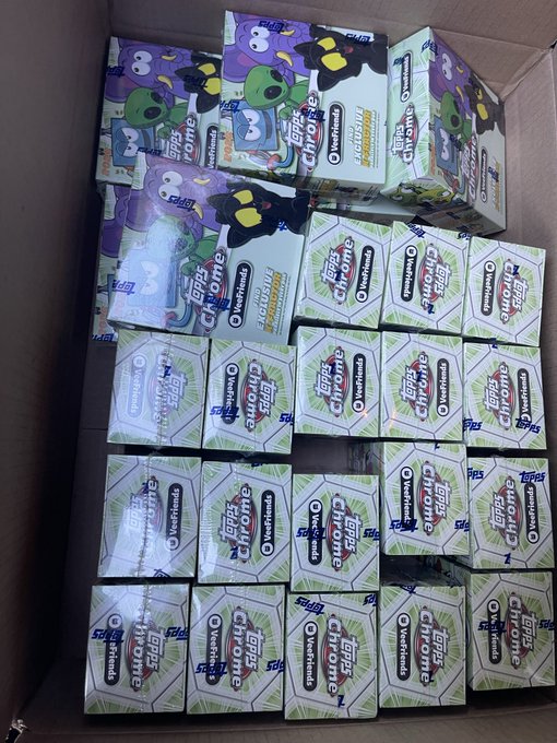 A cardboard box filled with multiple packs and boxes of Topps Chrome UEFA Club Competition cards, including boxes for 'Topps Chrome UEFA Club Competition Vespa Nears' and 'Topps Chrome'.