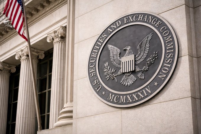 The U.S. Securities and Exchange Commission (SEC) seal featuring an eagle with a shield is mounted on the exterior of a stone building with classical columns and an American flag visible in the background.