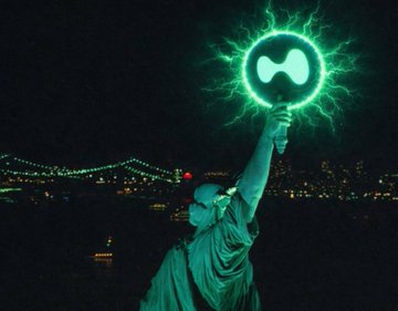An image of the Statue of Liberty holding a glowing green light orb featuring the Hyperliquid logo, with a cityscape in the background at night.