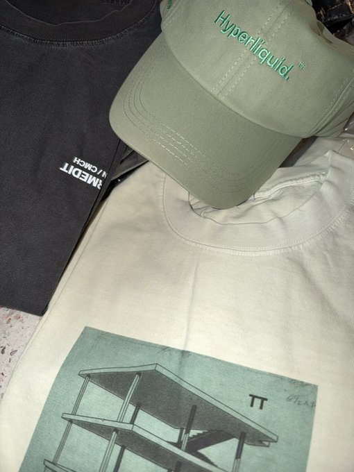 Close-up of apparel items including a black shirt with the word 'RUMEDIT', an olive green cap reading 'Hyperilliquid', and a white t-shirt featuring a graphic of a bed frame and the Greek letter π.