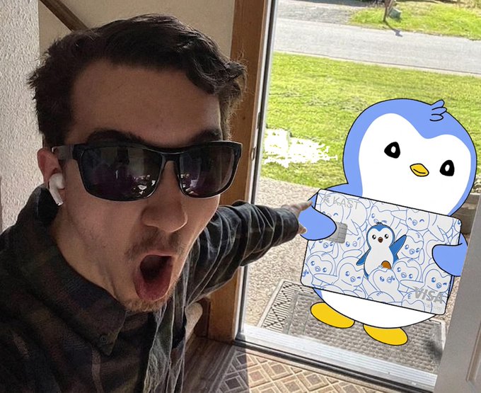 The image features a man wearing sunglasses and holding a penguin-themed gift card. The card has a picture of a penguin on it, indicating that it's for someone named Penguin Day or something related to penguins. The man appears to be excited about his gift and is posing with the penguin gift card in front of a window.