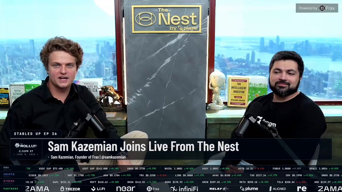 The image shows two men sitting behind microphones at a news station, appearing to be discussing an interview with @therollupco founder and CEO @samkazemian. The hosts are seated in front of a large window that offers a view of a city skyline. The backdrop features the words "The Nest" on a sign, indicating the location or event being covered by the news station.