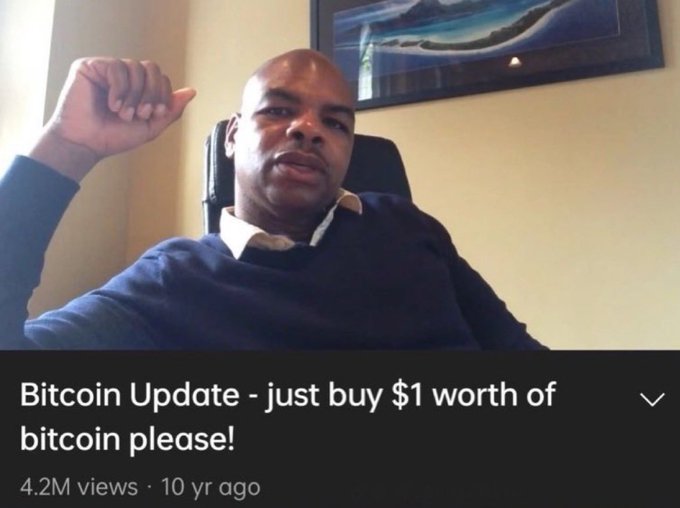A video thumbnail showing a bald man in a dark sweater pointing to his head, with the title 'Bitcoin Update - just buy $1 worth of bitcoin please!' showing 4.2M views from 10 years ago.