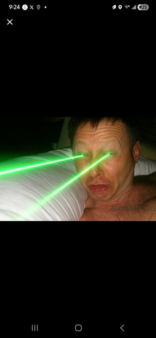 A man in bed with green laser beams shooting from his eyes and an open-mouthed expression, humorously capturing the sleepless intensity of watching XRP ("ALL NIGHT LONG $XRP") fluctuate through the early hours, as shown by the 9:24 timestamp on the phone screen.
