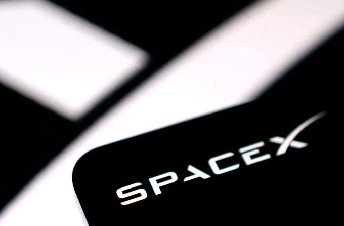 A close-up of a smartphone screen displaying the white "SPACEX" logo against a black background.