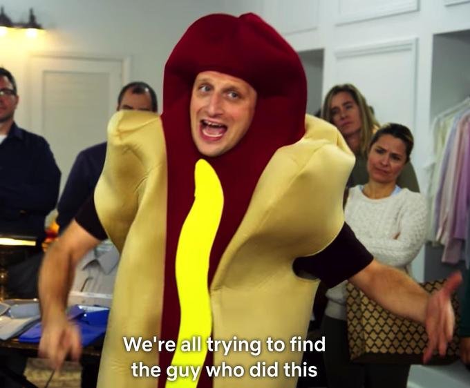 Meme image of a man wearing a hot dog costume with an exaggerated expression, captioned 'We're all trying to find the guy who did this', with confused onlookers in the background.