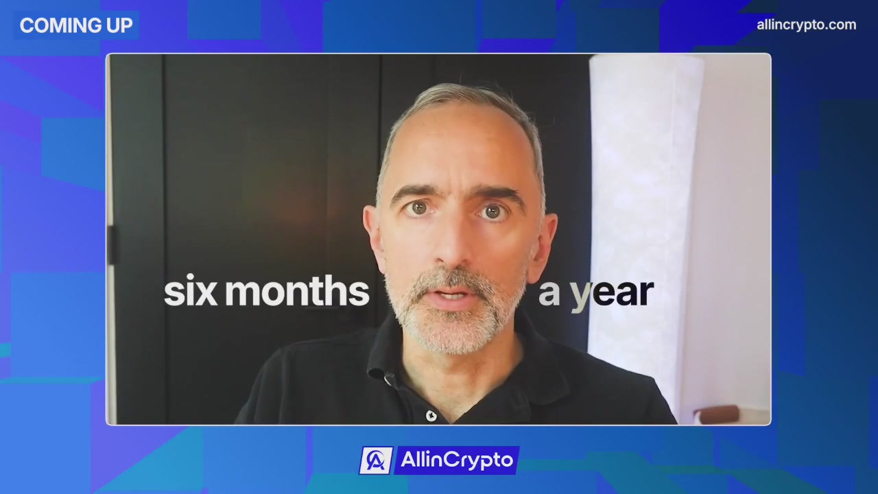 The image shows a man with a beard wearing a black shirt sitting at a desk. The background features a blue wall with white text, which reads "Six months coming up". This suggests that there might be an upcoming event or project related to stablecoins, CBDCs, or other financial innovations in the near future.