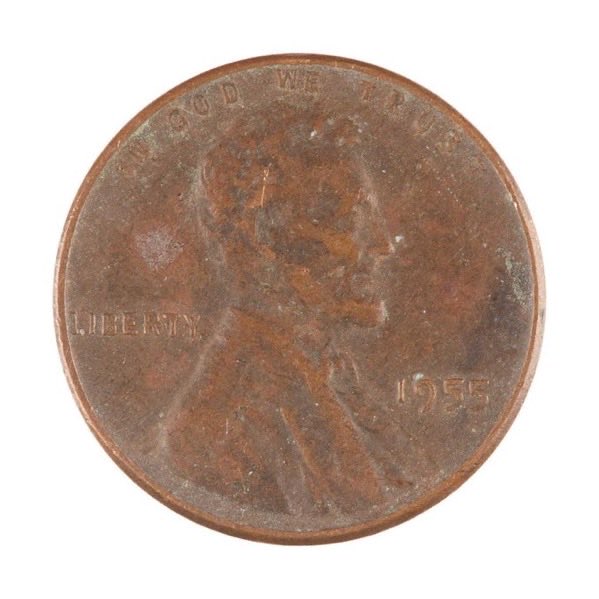 Close-up of a worn 1955 US Lincoln penny showing 'IN GOD WE TRUST' and 'LIBERTY' text