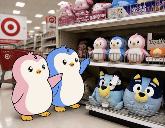 Two cartoon penguin characters (pink and blue) pointing at shelves of plush toys at Target, including penguin and dog stuffed animals, with K-Pop Demon Hunters merchandise visible above.
