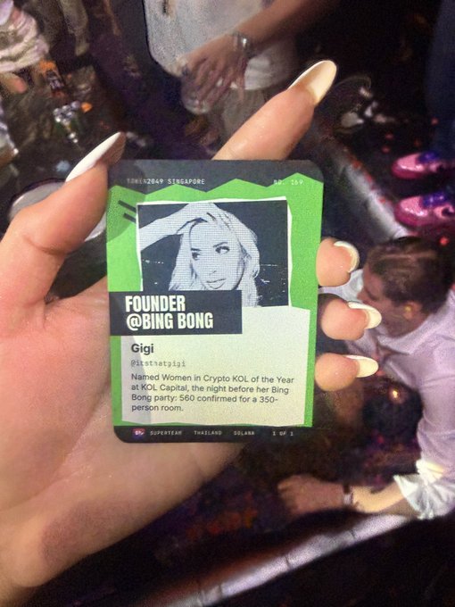 A hand holds up a Superteam Thailand ID badge featuring "Gigi, Founder @Bing Bong" and her 350-person room achievement, marking her as a Crypto KOL of the Year at the Bangkok Superteam Thailand event. The personalized badge reflects the celebratory vibe referenced in the post about @SuperteamTH.