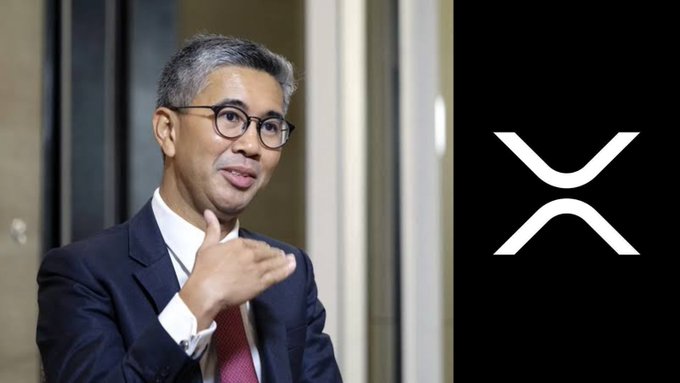 The image shows a man in a dark suit and glasses gesturing with his hand, alongside the XRP logo on a black background. The accompanying post about Malaysia's central bank endorsing XRP for the $300 trillion global payments industry relates to the XRP cryptocurrency branding shown prominently in the image.