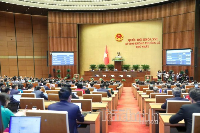 A formal session of the Vietnamese National Assembly's 15th legislature, 1st extraordinary session (Quốc Hội Khóa XV, Kỳ Họp Không Thường Lệ Thứ Nhất), with delegates seated facing a podium bearing the national emblem, illustrating the legislative body where the anti-money laundering bill addressing crypto asset services was considered.