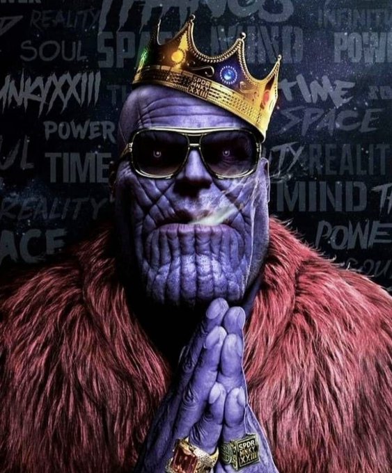 A digitally edited image of Thanos wearing a gold crown, sunglasses, and a red fur coat, with his hands clasped together against a background featuring words like "POWER," "SPACE," "REALITY," "TIME," and "MIND."