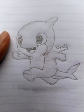 A pencil sketch on lined paper of a cute baby orca whale labeled "Orca," with a finger visible at the edge of the frame.