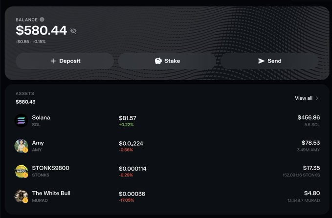 A crypto wallet dashboard displays a balance of $580.44 (down $0.85 or -0.15%), with assets including Solana ($456.86), Amy ($78.53), STONKS9800 ($17.35), and The White Bull token ($4.80). The image illustrates the post's theme of unpredictable crypto balances, featuring a meme token "STONKS9800" alongside traditional holdings—a fitting visual representation of how today's random portfolio may reflect tomorrow's unpredictable experiment in internet-driven financial coordination.