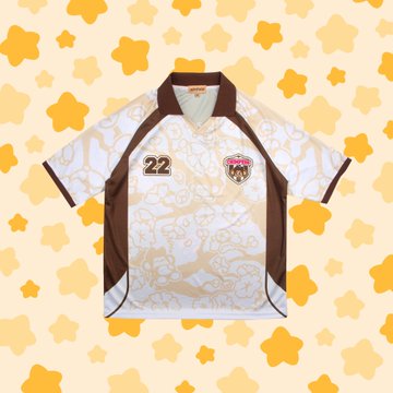 A white and brown sports jersey with the number 22 and a team crest displayed on a star-patterned yellow background.