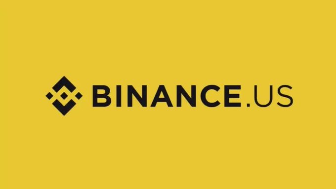 The image displays the Binance.US logo on a bright yellow background, featuring the platform's distinctive diamond-shaped icon alongside the "BINANCE.US" text. This branding directly corresponds to the post's announcement about Binance.US potentially entering the prediction markets space, highlighting the company's expansion into event-based trading following CFTC approval.