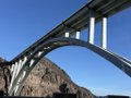 A view of the Mike O'Callaghan–Pat Tillman Memorial Bridge, a large concrete arch bridge spanning over the Hoover Dam area with rocky canyon walls visible beneath it.