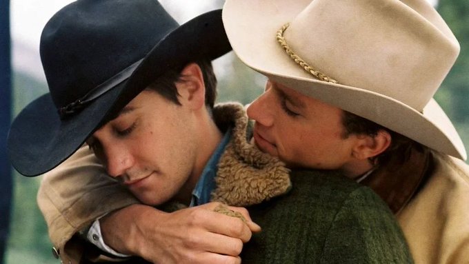 Two cowboys in black and white cowboy hats share an intimate embrace, with one pressing his face against the other's shoulder in a tender, close moment. The image appears to metaphorically depict the post's humor about crypto protocols being intimate copies of one another, capturing a "loving" or "borrowing" embrace between two projects like the cowboy characters.