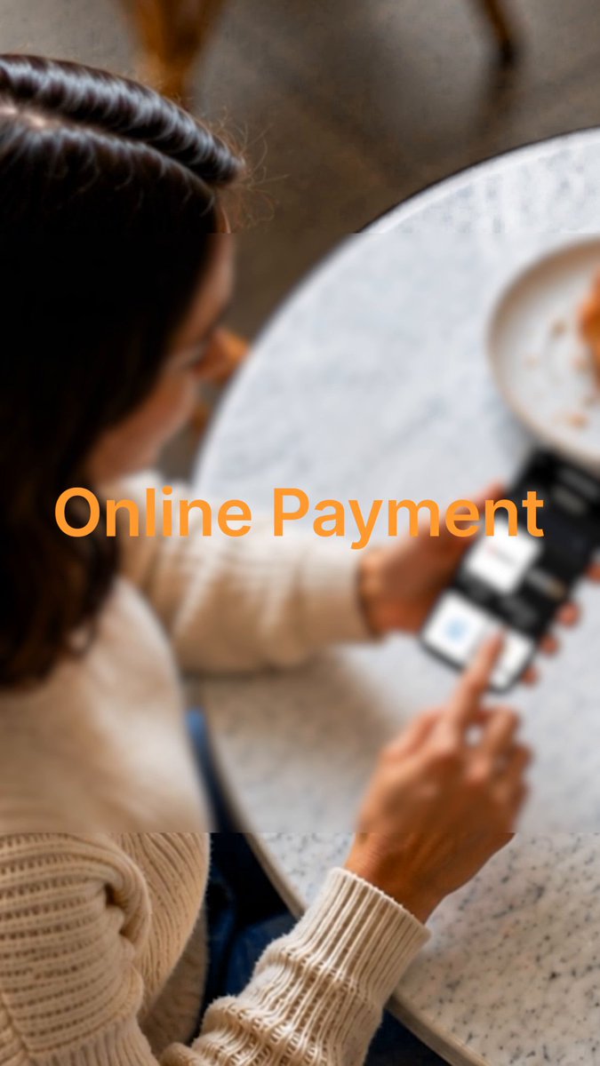 The image shows a person from behind, using a smartphone at a marble café table, with the bold orange text "Online Payment" overlaid across the center. The scene captures the simplicity of everyday digital transactions, illustrating how crypto is being integrated into routine, real-world purchases like a quick coffee.

Online Payment