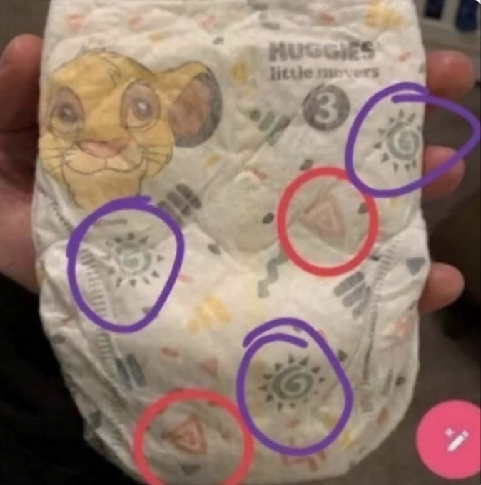 A photo of a Huggies Little Movers Size 3 diaper held in a hand, with purple and red circles drawn by the user highlighting the printed wetness indicator designs (suns and triangles) on the diaper's surface.