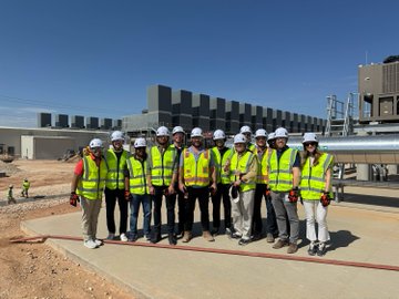 A group of workers and executives in hard hats and high-visibility vests pose at the Helios data center site in West Texas, with the $GLXY ticker tying the photo to Galaxy Digital's operational AI compute infrastructure. The image visually reinforces the post's message by showing the team on-site at the active buildout, rather than just discussing it.