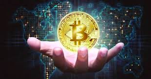 A hand holding a glowing golden Bitcoin coin against a dark world map background dotted with digital connections.