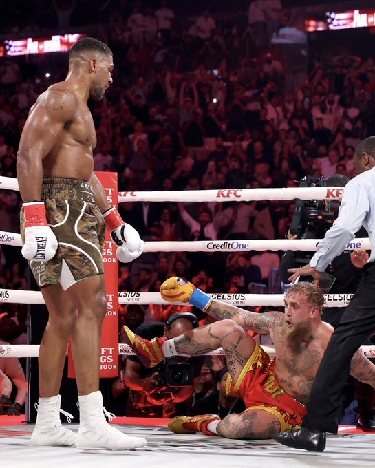 A boxing match scene shows a victorious fighter in camo shorts standing over his seated opponent in red and yellow shorts, with KFC and Credit One bank advertisements visible on the ring.
