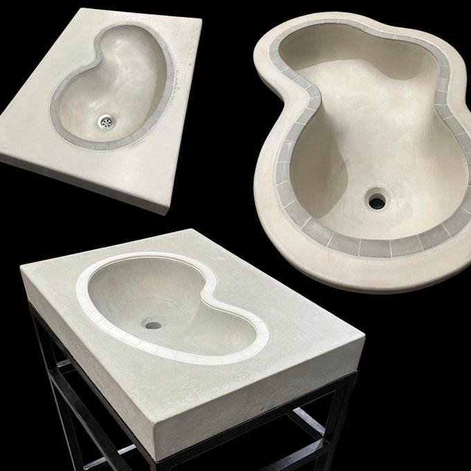 Three views of a unique figure-eight shaped concrete basin or sink with a pebbled tile inlay along the inner rim, shown freestanding and on a metal stand.