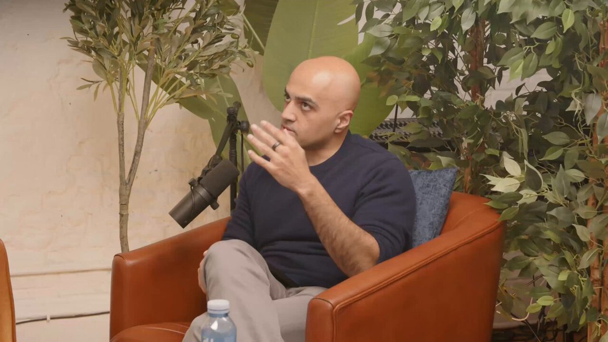 The image features a man sitting comfortably in an orange chair with a plant behind him. The man appears to be wearing a blue shirt, and he has a bottle of water next to him. There are two chairs visible in the scene - one where the man is seated and another that is empty. A microphone can also be seen near the center of the image.

The post includes text discussing various topics related to cryptocurrency and blockchain technology. The main focus seems to be on Ethereum, with a discussion about its vulnerabilities and potential threats. The man in the chair appears to be listening intently or possibly participating in the conversation.